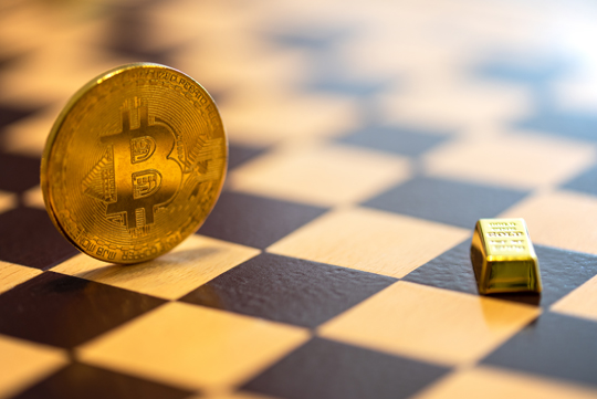 bitcoin token and a gold bar